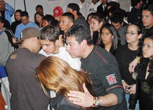 A young man comes forward to give his life to Christ at a REgaeton concert at CAmino de Vida