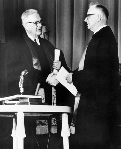 Evangelical United Brethren Church Bishop Reuben H. Mueller (left) and Methodist Bishop Lloyd C. Wicke join hands on April 23, 1968. Photo courtesy of the United Methodist Commission on Archives and History.