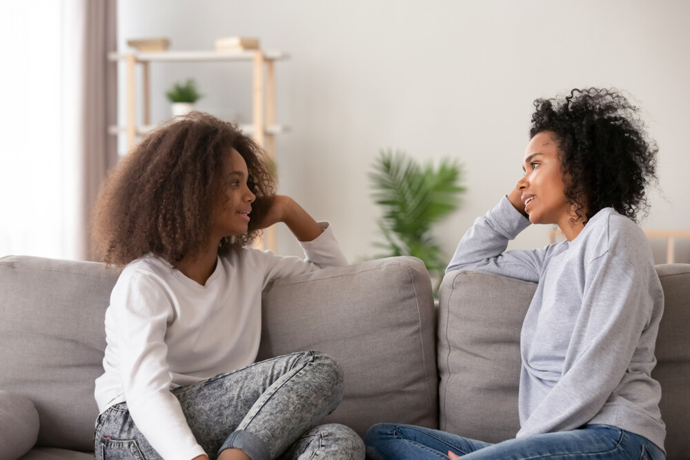 mother-talking-with-teen-daughter-on-the-sofa-at-home