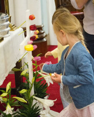 Kids putting Easter flowers on cross