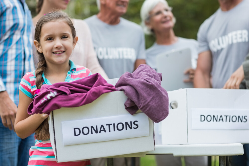 girl-holding-box-of-donations-volunteering-with-family