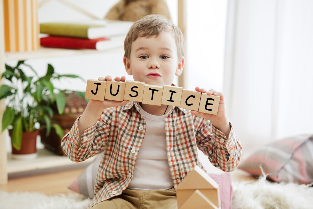 young-boy-holding-up-wood-blocks-with-the-word-justice