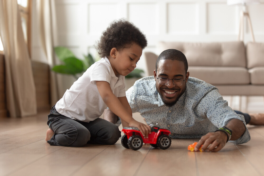 young-dad-on-the-floor-playing-toy-cars-with-young-son