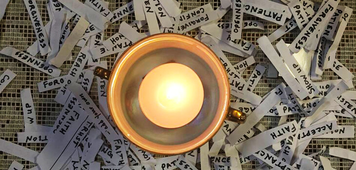 Flaming chalice surrounded by slips of paper with virtues written on them