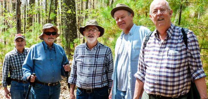 Five men hiking and smiling