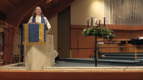 Associate Rector Anna Scherer preaching at the pulpit with an Advent wreath to her left