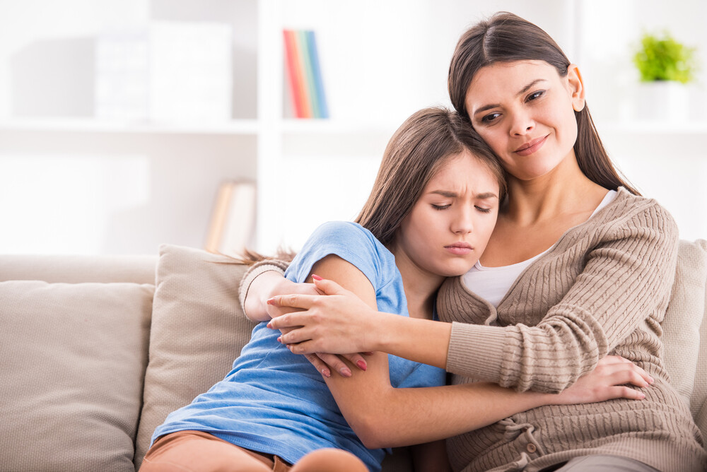 mother-and-teen-daughter-hugging-on-the-sofa-after-quarrel