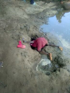 A girl burrows in the riverbed for water to drink. Dindi school children are risking their health and their lives drinking this unsafe water, which was their only option in March. Photo by Luckymore Mudzengerere, UMNS