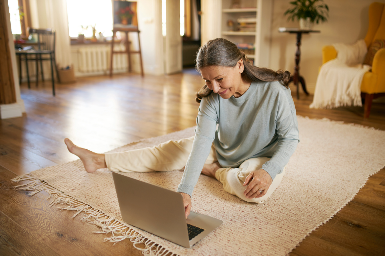 woman stretching on ground in front of computer