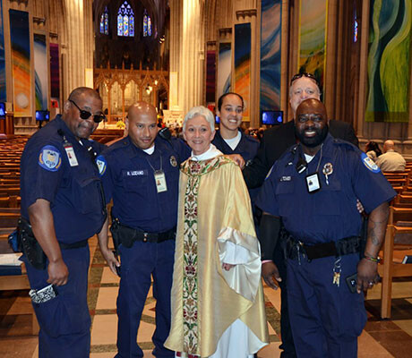 The Rev. Gina Campbell, center, stands with members of the Security Team at Washington National Cathedral on April 17. Campbell, who is the first non-Episcopalian to serve as worship director at the Cathedral, is leaving her post after 8 years.