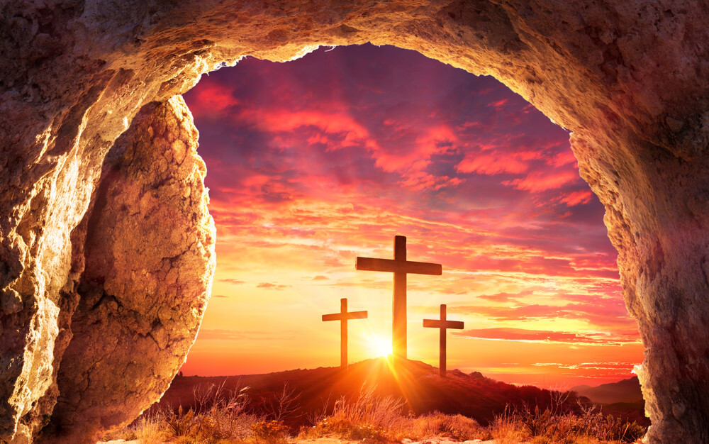 Easter-concept-tomb-opening-to-view-of-cross-against-the-sunset