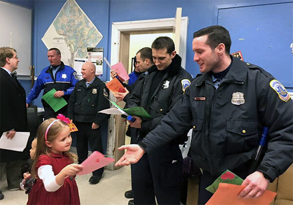 A young member of Captiol Hill UMC hands out Valentines during a visit to the First District Substation in Washington, D.C.