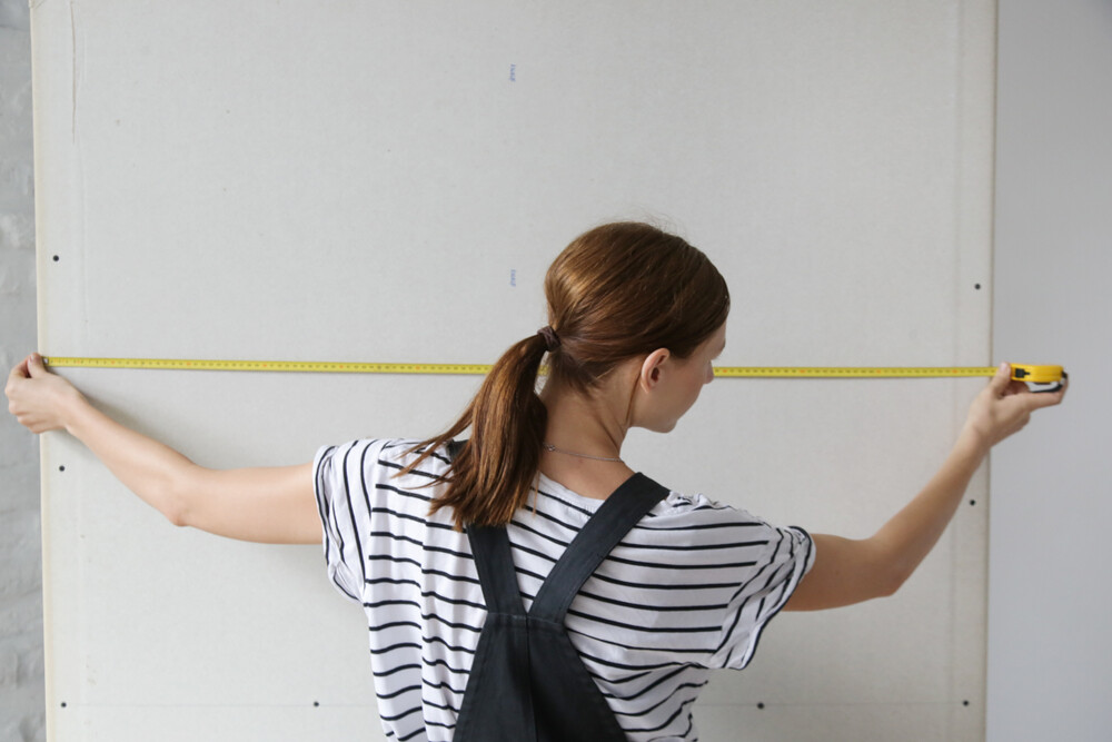 back-view-of-woman-holding-tape-measure-home-improvement-concept