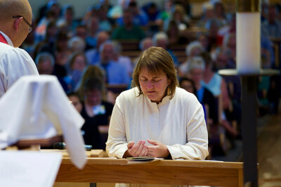 Bishop Karen Oliveto, the first openly gay bishop in The United Methodist Church, kneels during the consecration service held on July 16, 2016, at Paradise Valley United Methodist Church in Scottsdale, Arizona. Photo by Patrick Scriven, Pacific-Northwest Conference.