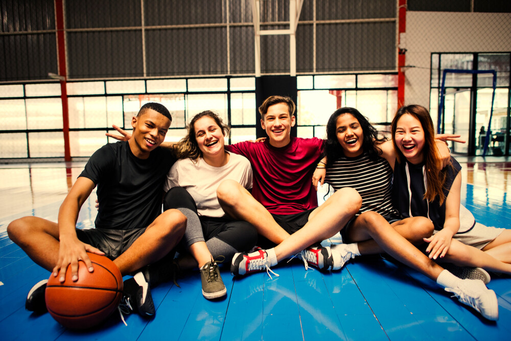 group-of-middle-schoolers-with-a-basketball-smiling-and-embracing