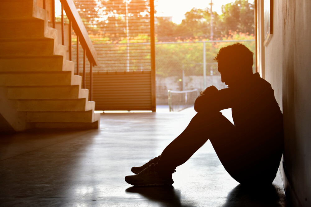 silhouette-of-man-struggling-with-depression-sitting-on-the-floor