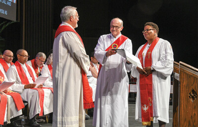 Rev. William Thomas, left, is readmitted to the Order of Elders by Bishop LaTrelle Easterling, right.