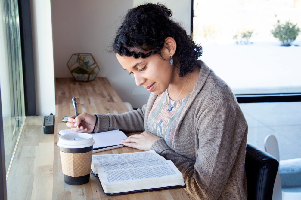 young-african-american-woman-taking-notes-while-studying-the-Bible