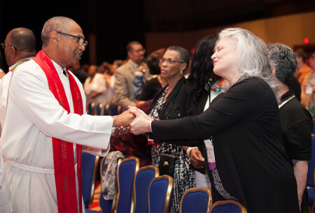 “I need you to survive,” members of the BWC, including the Rev. Gerry Green, left, and Ella Curry, sing to one another at opening worship Wednesday evening.