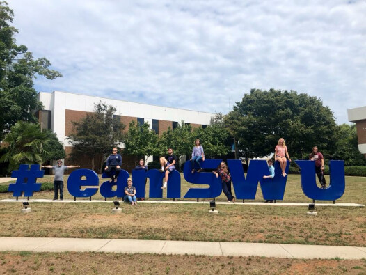 University Singers pose around the #TeamSWU sign on the campus of Southern Wesleyan University