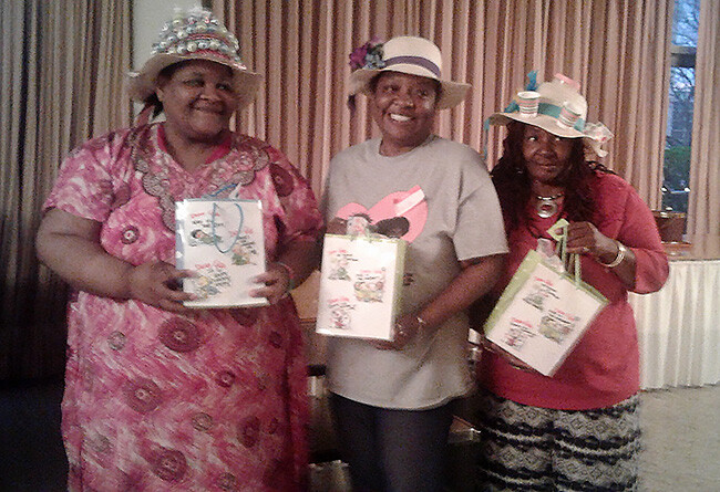 At the Women’s Retreat, three winners of the Strawhat Decoration Contest show off their prizes for creating the most beautiful, the most creative and the funniest hats. Photo by Nancy Green.