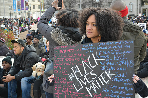 A young woman holds a sign at a protest march in Washington DC to bring attention to the recent shooting deaths of several unarmed black men by police. Source: iStockPhoto.