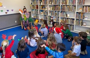 teacher reading aloud to children in a library