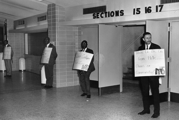 “Where do we go from here… Chaos or Community?” appears on the sign held by the Rev. Gilbert H. Caldwell by the entrance to the plenary for the 1968 Uniting Conference in Dallas. The phrase is the title of the Rev. Martin Luther King Jr.’s final book, and a reminder of the church's ongoing call to confront racism. Photo courtesy of Archives and History.