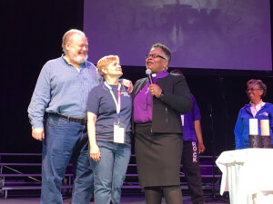 Tom and Becki Price, left, stand with Bishop LaTrelle Easterling on stage at ROCK.